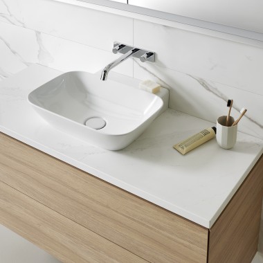 Umivaonik od bijele keramike s kupaonskim namještajem od drva (© Geberit)