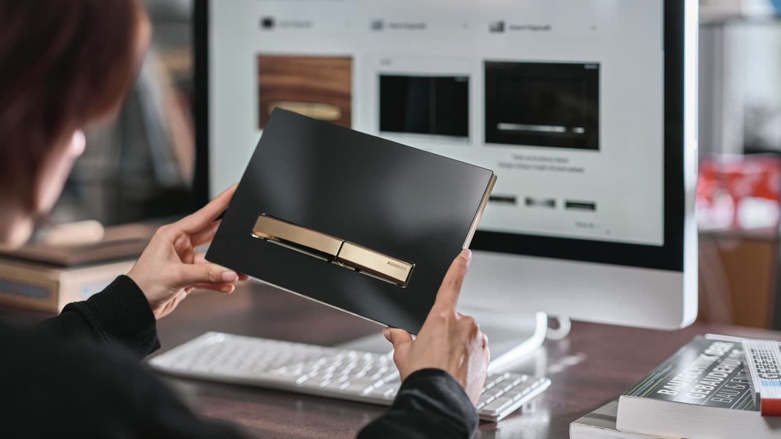 Žena s tipkom za aktiviranje ispiranja Geberit Sigma50 u ružičasto-zlatnoj boji Žena s tipkom za aktiviranje ispiranja Geberit Sigma50 u ružičasto-zlatnoj boji